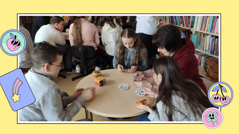 Zdjęcie kolorowe, siódmoklasiści grający w gry planszowe w Bibliotece